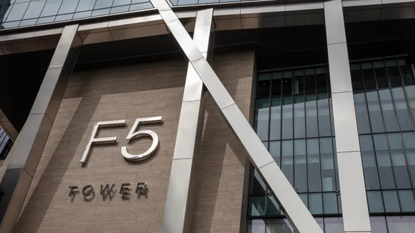 The words "F5 Tower" are displayed on the outside of a metal-and-wood building with many windows.
