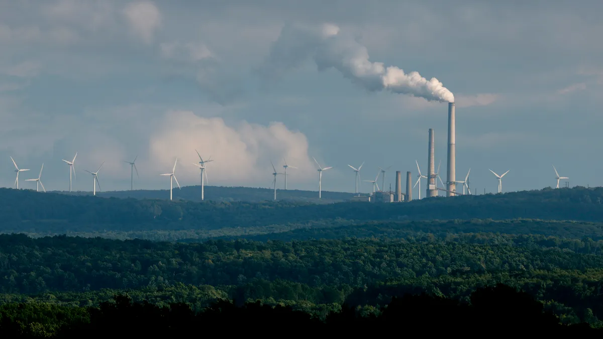 Turbines from the Mount Storm Wind Farm stand in the distance behind the Dominion Mount Storm power station in West Virginia.