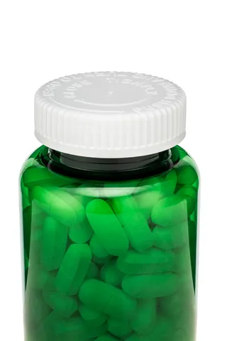A green bottle containing pills has a white cap.