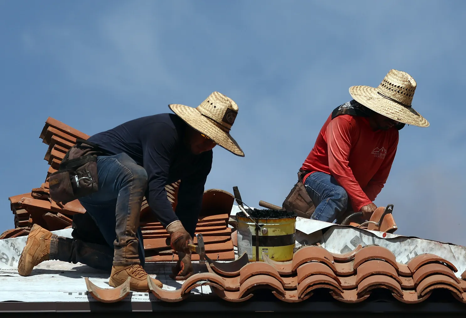 Workers on a roof on a sunny day.