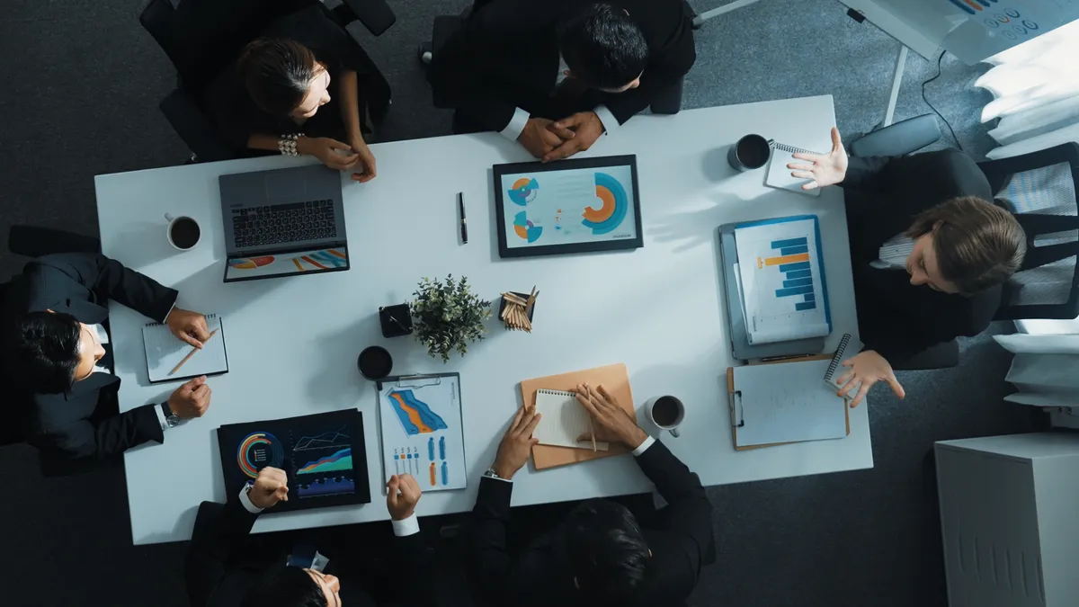 an overhead shot of an executive board reviewing data visualizations