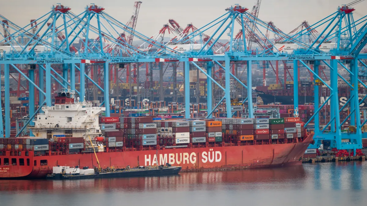 Cranes stand over a cargo ship at the Port of Newark on March 26, 2024