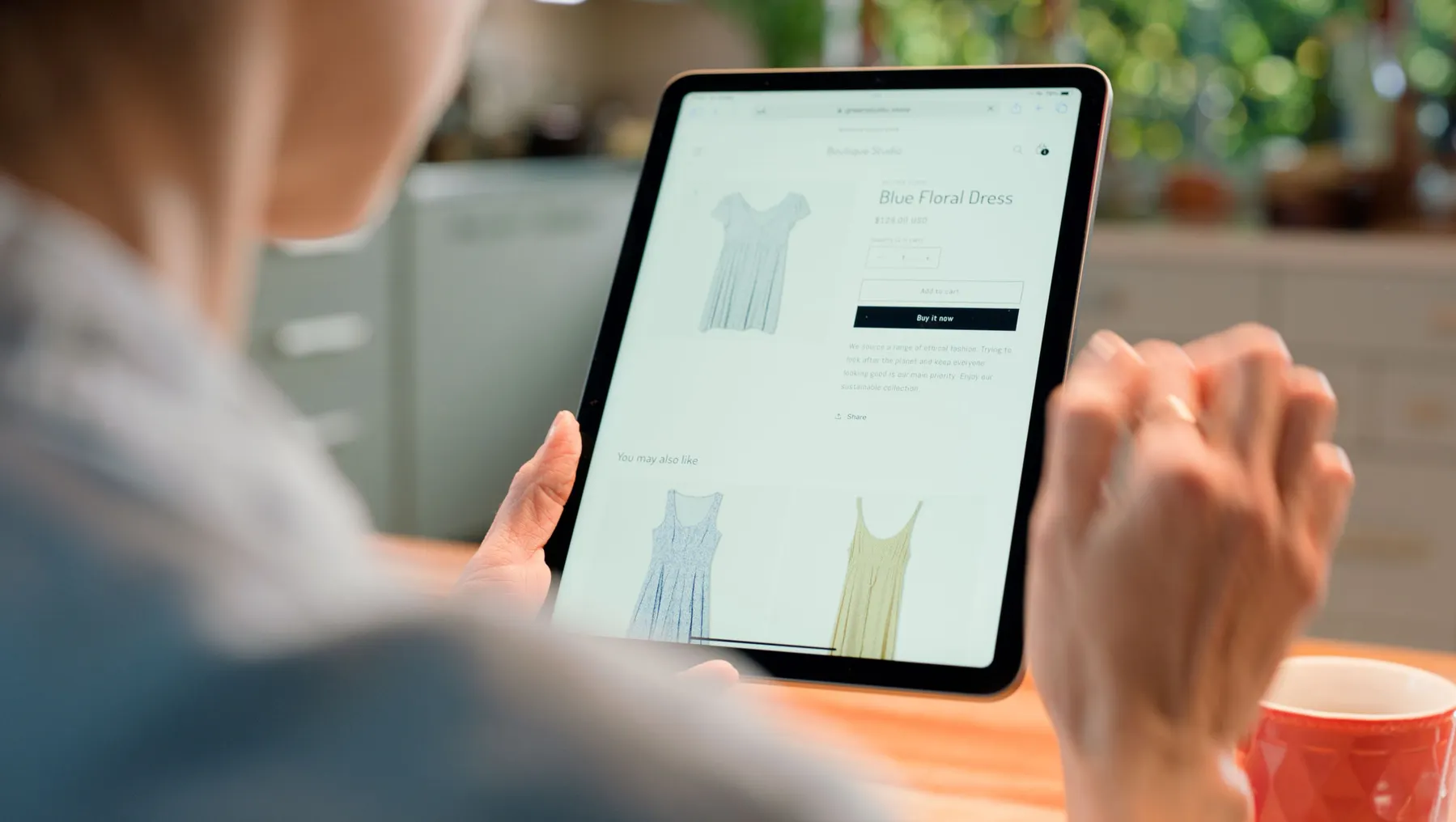 A person shops for clothing on a tablet.