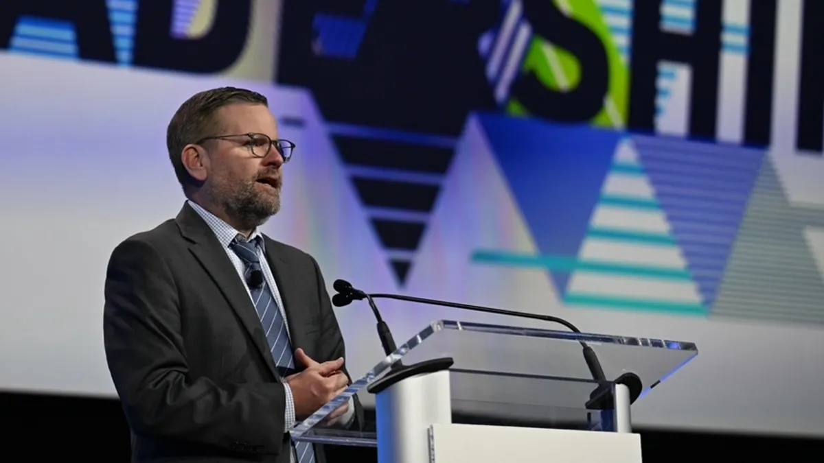 AASA Executive Director David Schuler speaks on a convention hall stage during a keynote session.