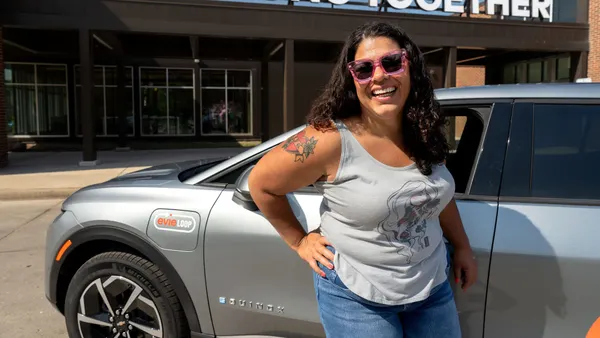 A person standing by the side of a car.
