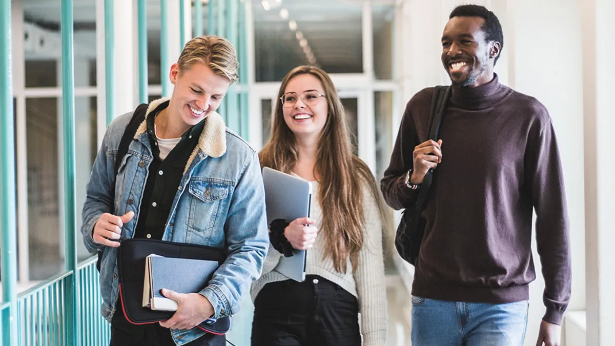 Students talking while walking in corridor of university