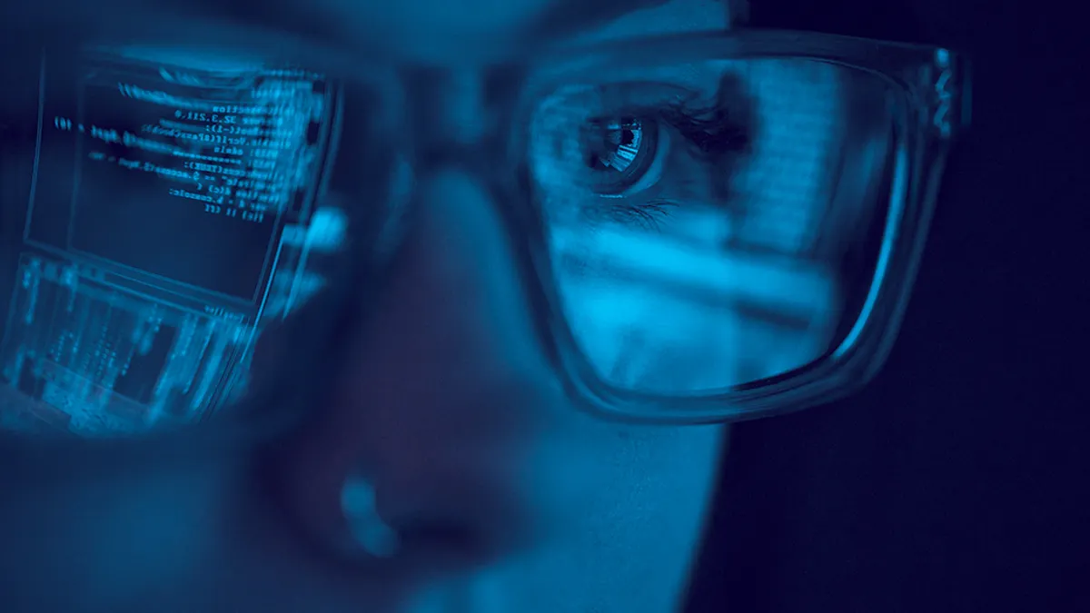 closeup of women wearing glasses with reflection of content from laptop