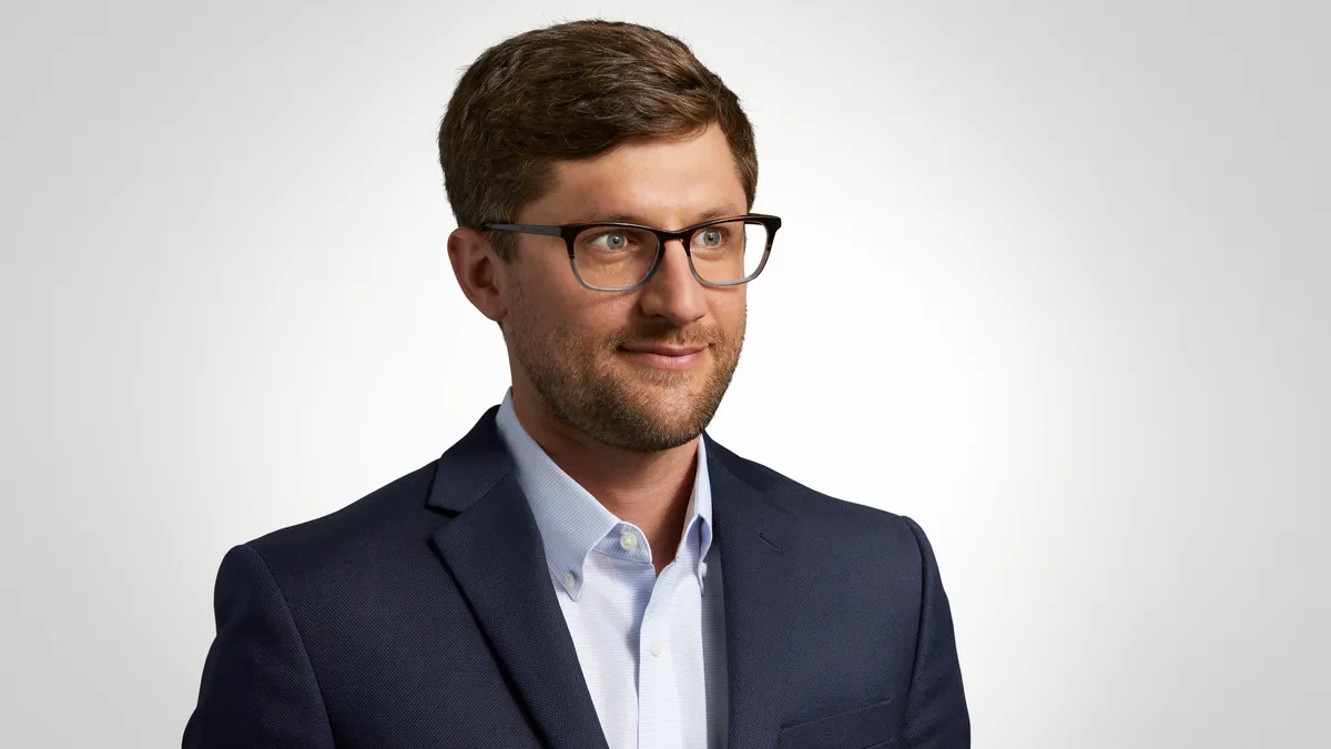 Intuitive Surgical's Tony Jarc is wearing a dark blue jacket and white shirt in a corporate head shot.