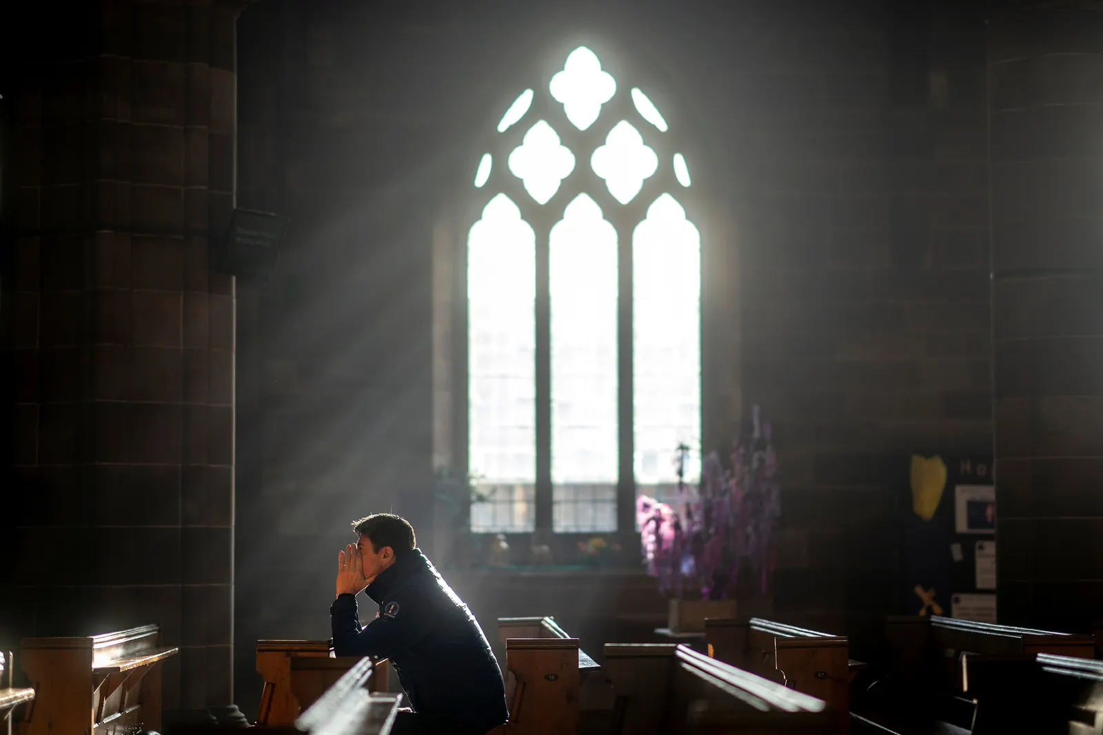 Man kneeling in prayer at Christian church