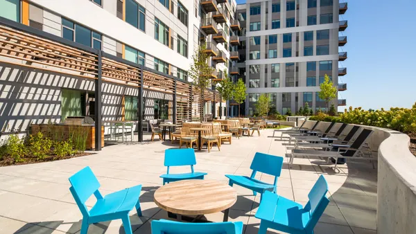 The sun deck of a tan, modern high-rise apartment building.