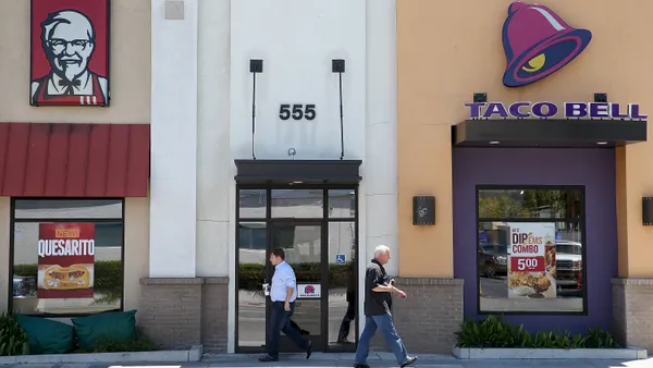 Pedestrians walk by a KFC and a Taco Bell restaurant on July 2, 2014 in San Rafael, California.