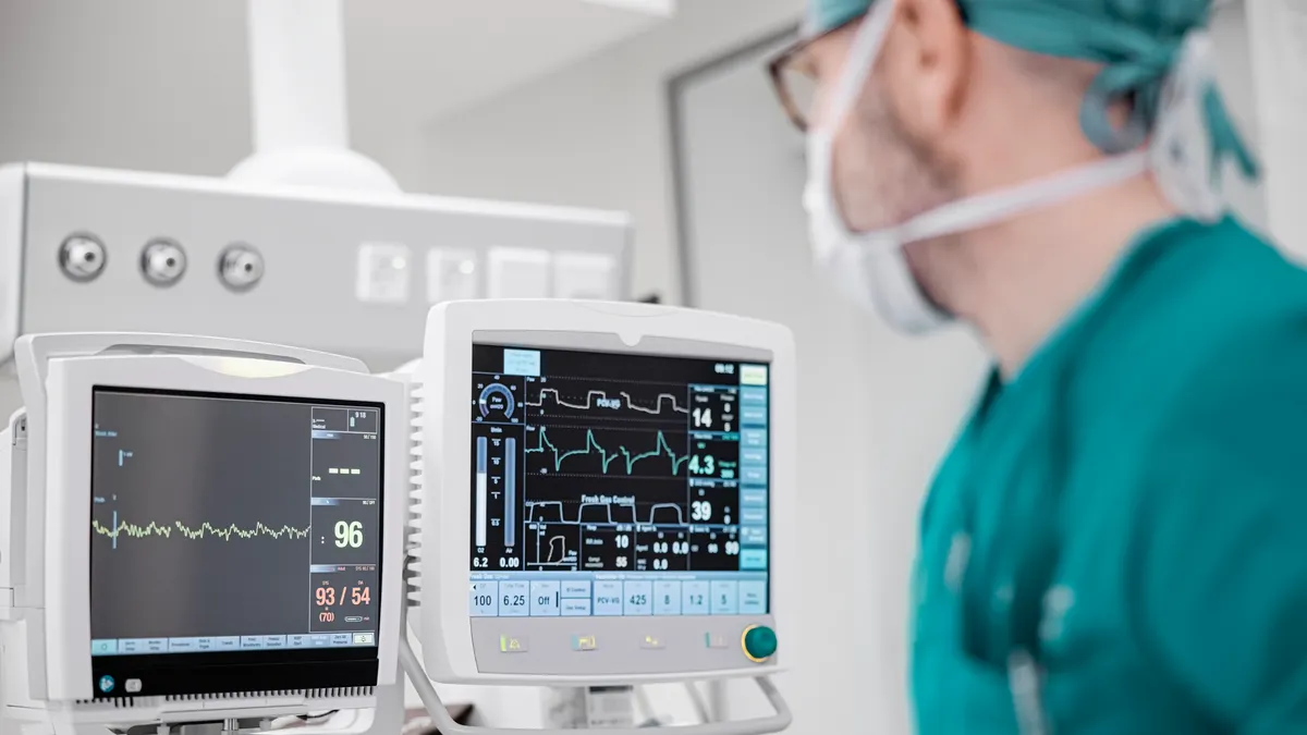 Male surgeon looking at the monitoring equipment during surgery.
