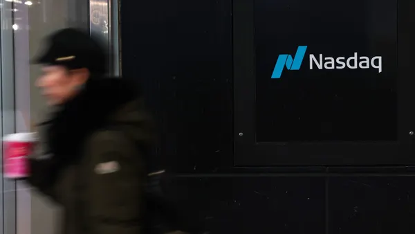 A man passes by the Nasdaq MarketSite sign.