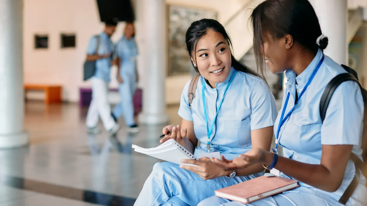 Medical students communicating while learning at university hallway