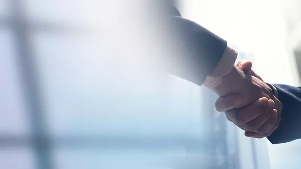 Two people shake hands in a stock photo.