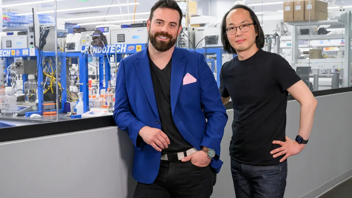 Strand Therapeutics co-founders Jake Becraft and Tasuku Kitada pose in a laboratory setting.