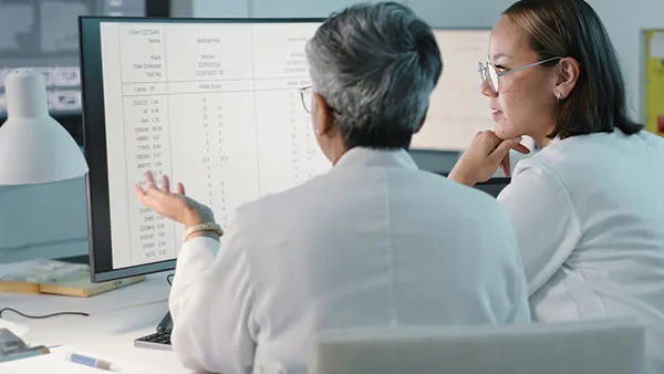 Doctors checking charts on computer screen