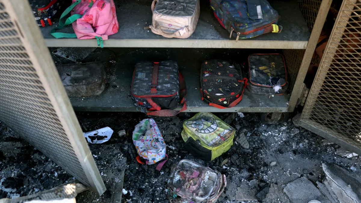 Burnt lunchboxes sit on different shelves in a metal locker.