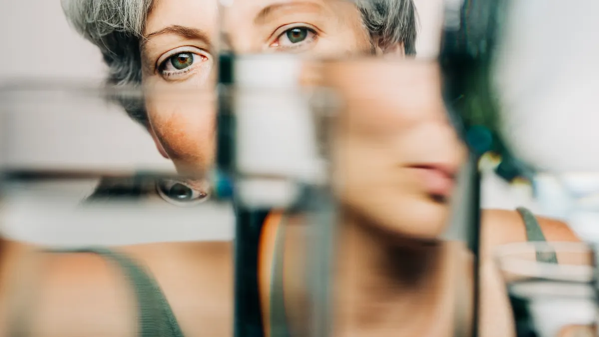 a woman's face seen through glasses of water