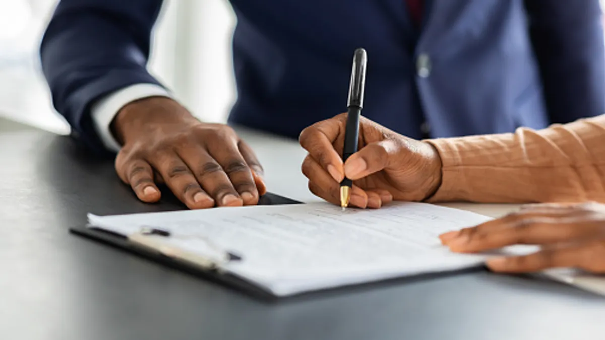 Close up shot of a person signing a contract