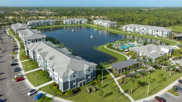 Aerial view of apartment property surrounding a lake