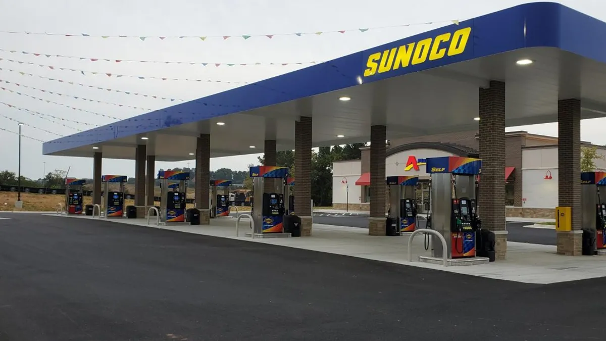 A photo of a convenience store and gas station. The fuel canopy reads "Sunoco" while a sign on the store says "A Plus."