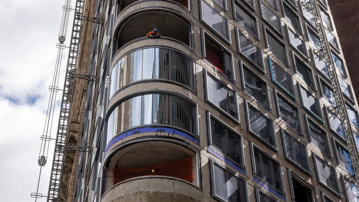 A worker peers out from a worksite in lower Manhattan