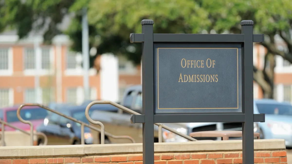 A sign advertises a college admissions office.