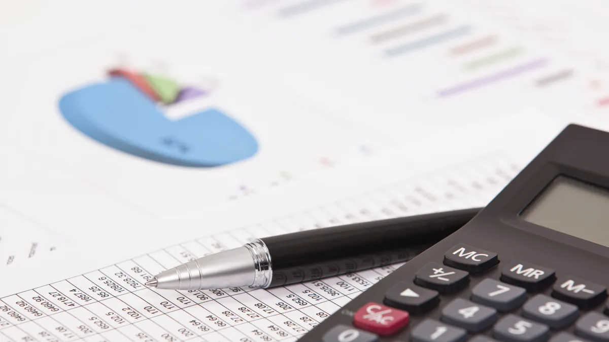 A stock image of a calculator alongside financial numbers