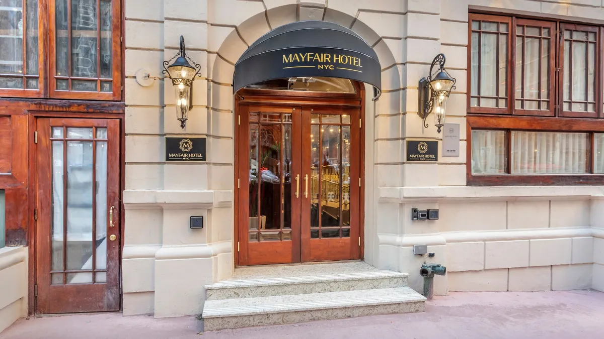 The exterior of the Mayfair Hotel features a black awning.