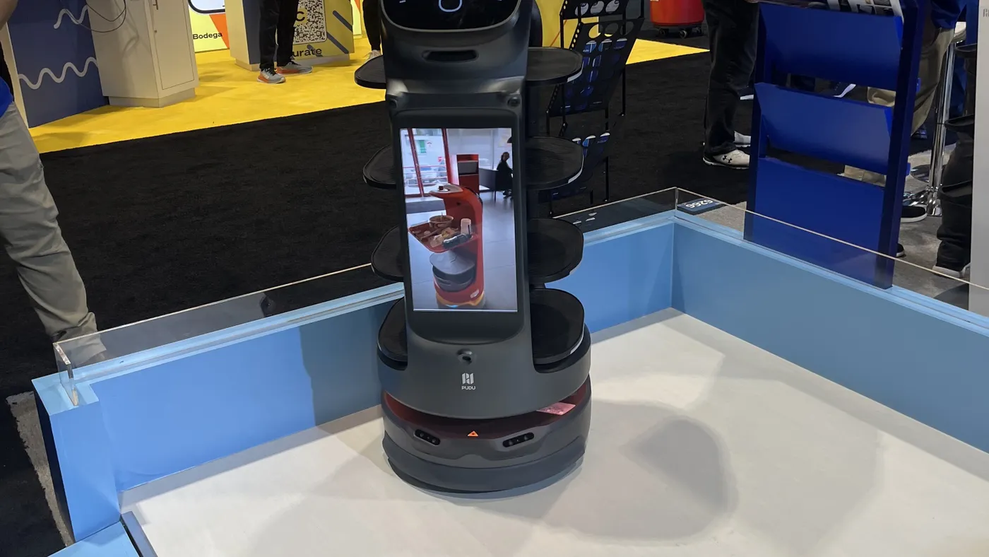 A robot table busser with a cat face on a tablet screen.