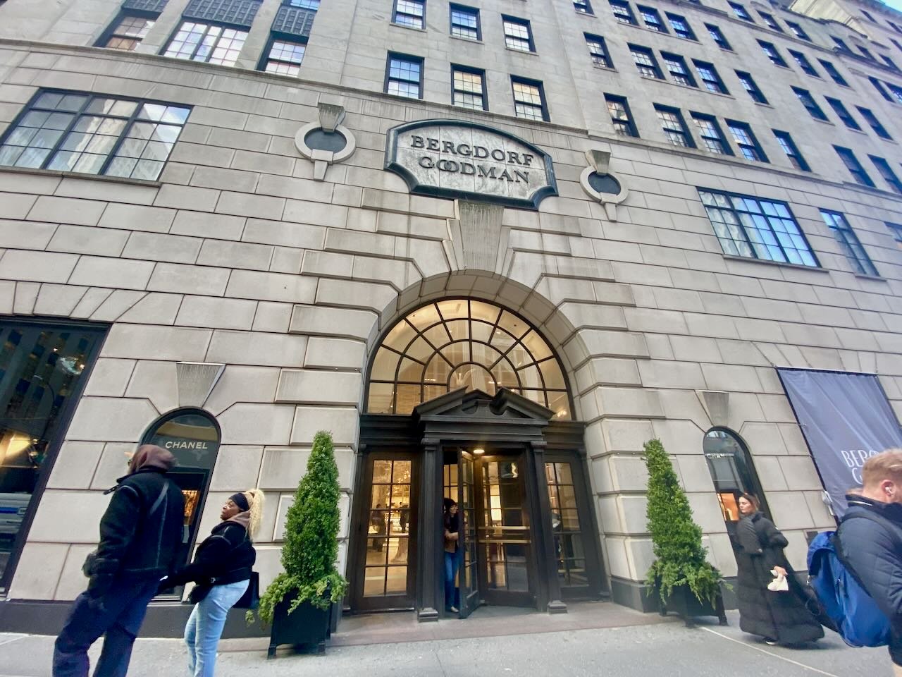 People walk past an city department store entrance.