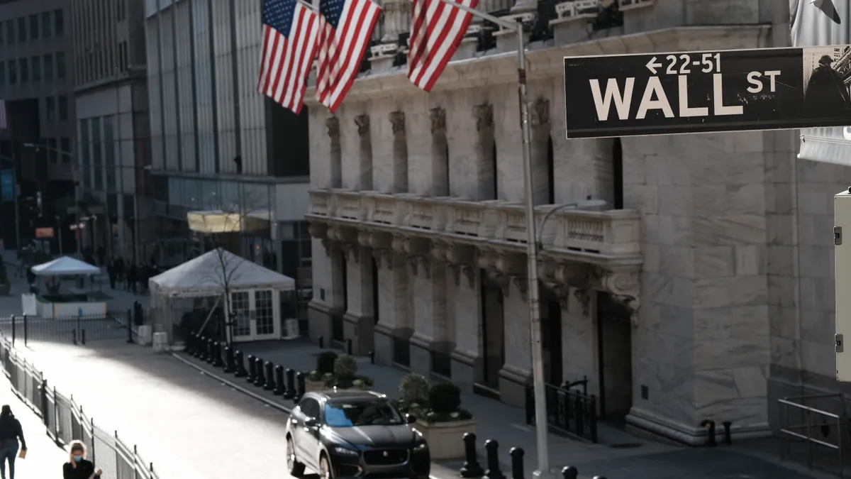 Picture of the New York stock exchange and the Wall Street sign.