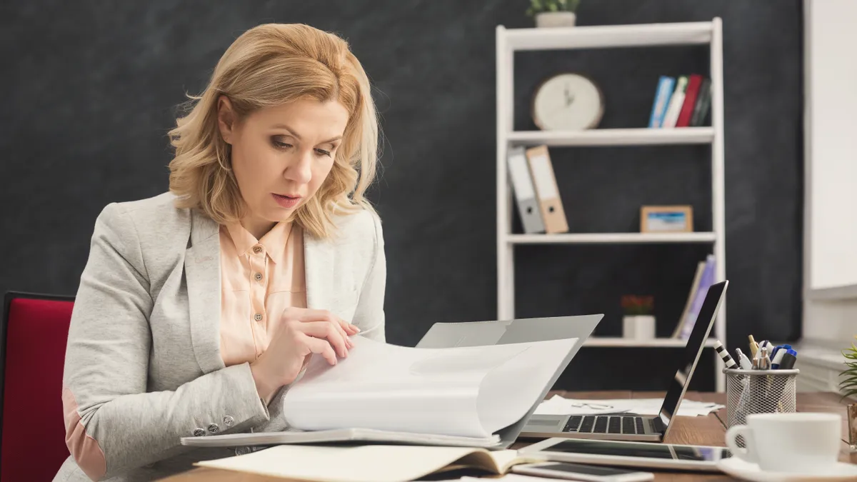 Businesswoman reading document at office desktop