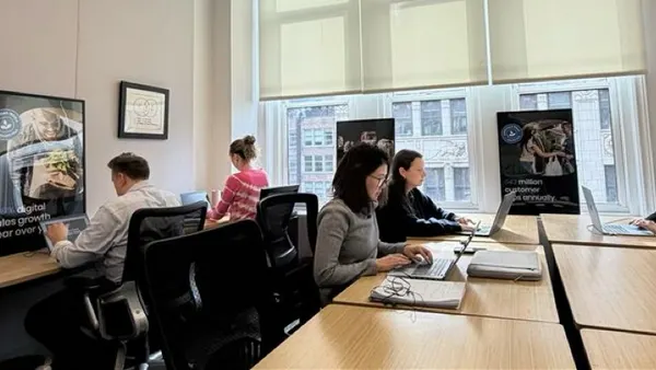 Image of people working independently at computers in an office