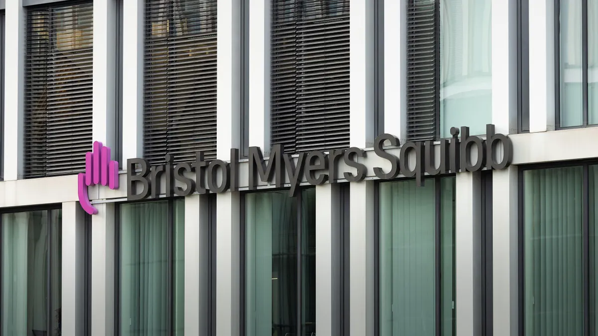 Modern glass window office building facade with the logo of Bristol Myers Squibb. 