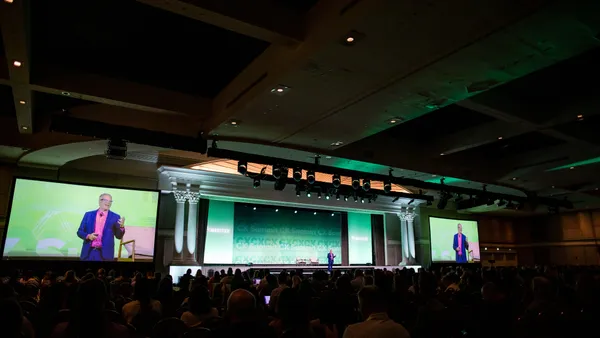 A person walks on a stage and gives a speech.