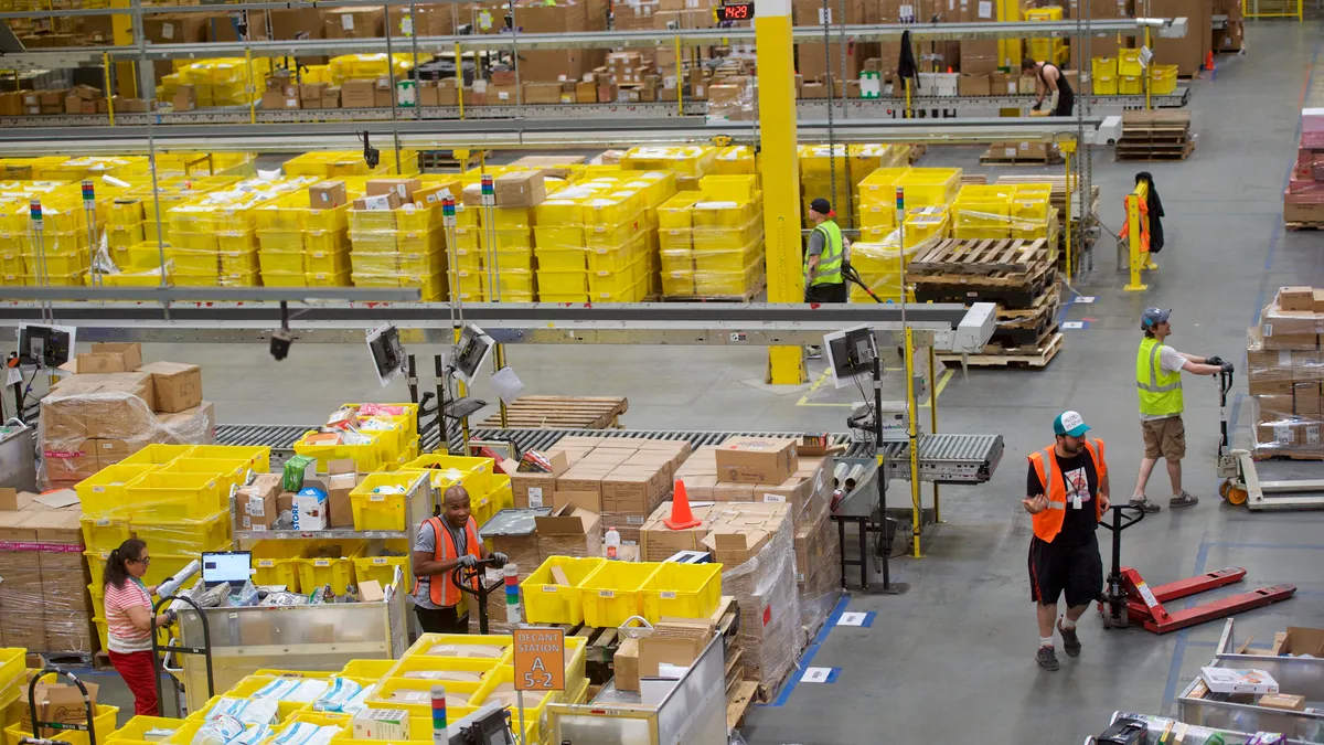 Employees working in an Amazon fulfillment center are seen from above.