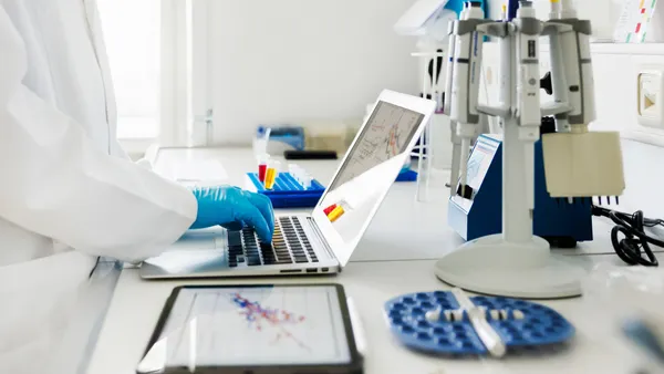 Close-Up Shot of Scientists Hands typing Data in Laptop in Laboratory