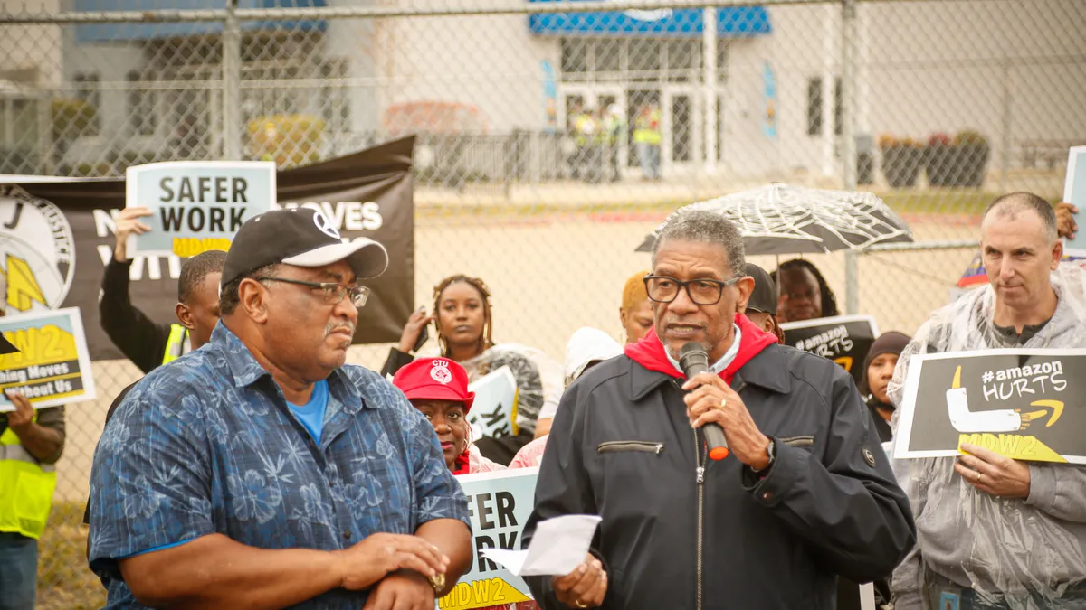 A group of labor organizers demand better pay and working conditions in front of an Amazon warehouse.