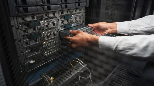 Close up side view portrait of an engineer handling computer hardware equipment in a server room.