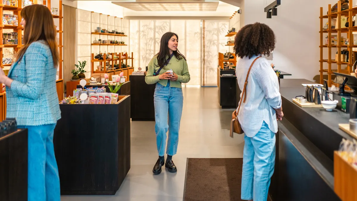 Three customers shop at a retail store.