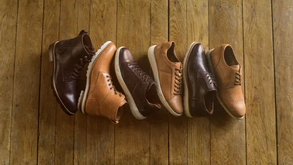 Six pieces of footwear lie on a wooden floor.