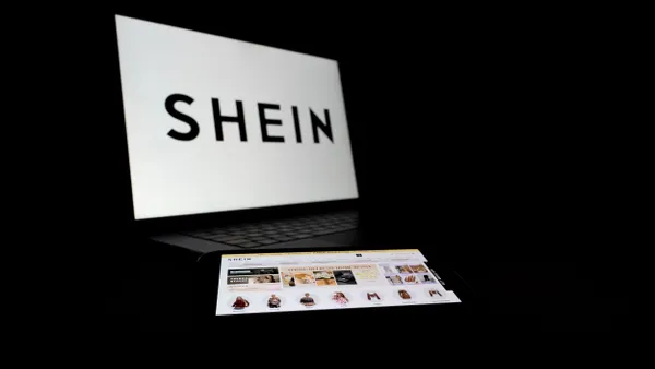 A Shein logo displayed on a laptop against a dark background.