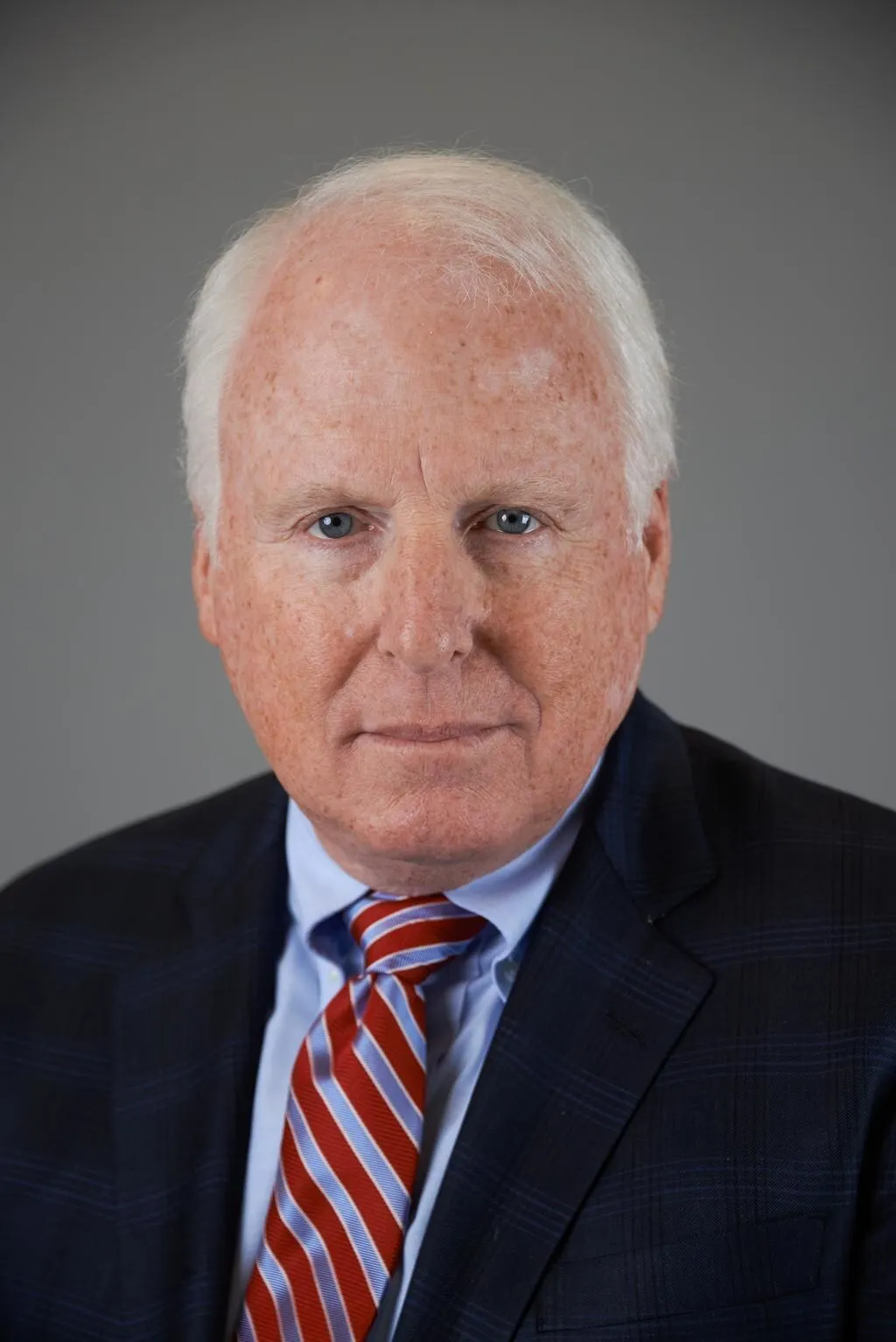 A head and shoulders photo of a person against a gray background.