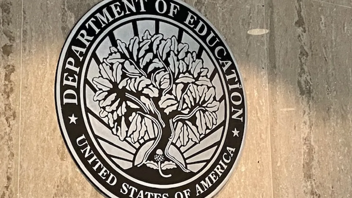 Seal of the U.S. Department of Education on a wall.