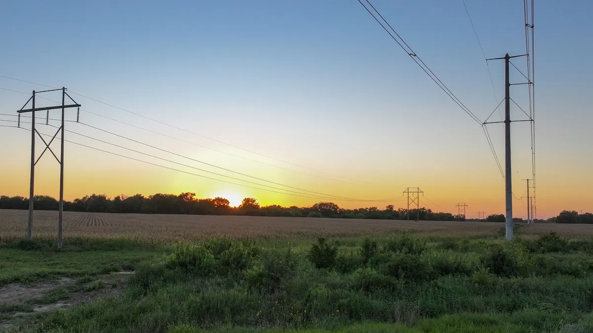 Electric transmission lines cross a field.