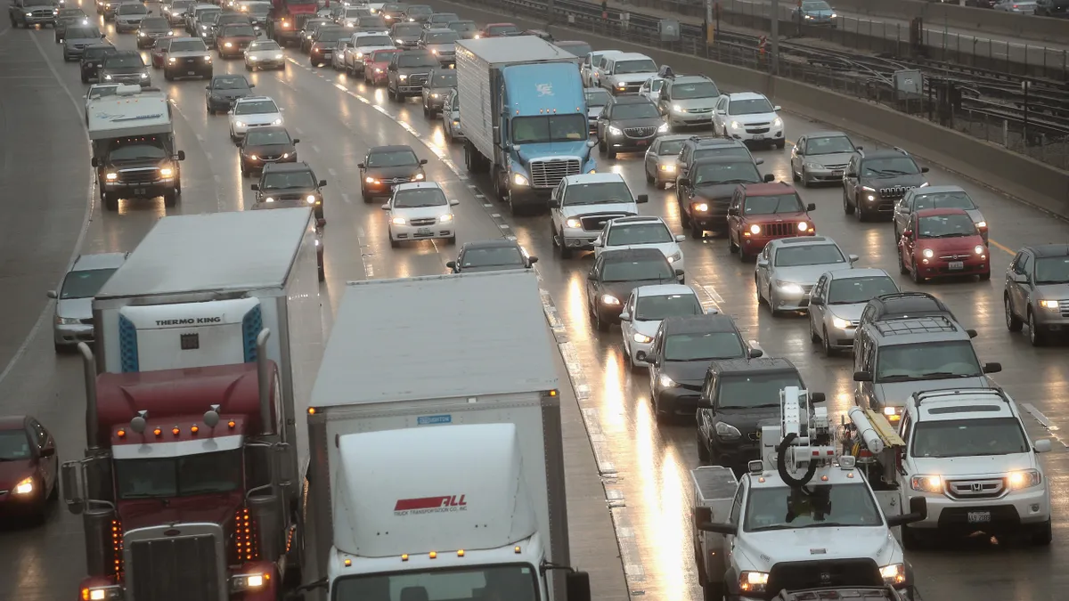 Looking down at a traffic jam on a six-lane highway in the evening with headlights on.