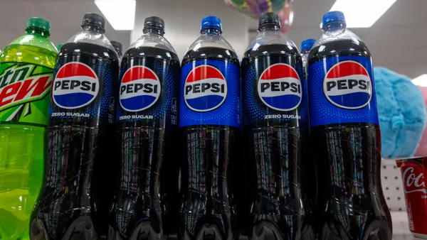 bottles of Pepsi and Mountain Dew are next to each other on a store shelf.
