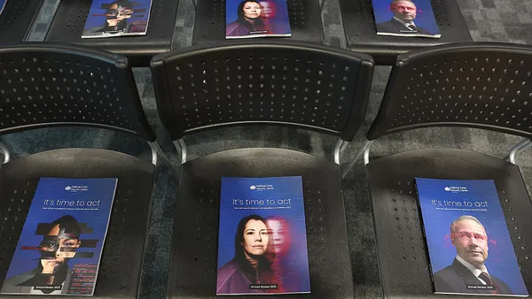 Booklets are placed on black chairs.